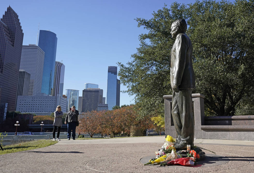 Deitz Kracker, a la izquierda, y Marg Frazier visitan una estatua del ex presidente George H.W. Bush en el centro de Houston, domingo 2 de diciembre de 2018. Bush murió el viernes por la noche en ...