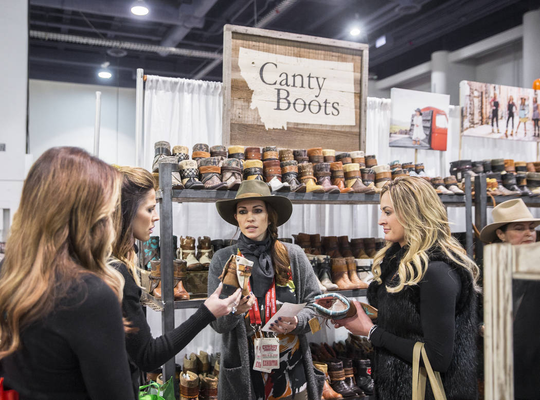 Nikki Edmundson, en medio, ayuda a los clientes de Canty Boots, con sede en Montana, durante Cowboy Christmas en el Centro de Convenciones de Las Vegas el jueves 6 de diciembre de 2018, en Las Veg ...