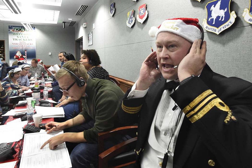 ARCHIVO - En esta foto de archivo del 24 de diciembre de 2017, el teniente mayor canadiense Chris Hache, recibe una llamada mientras trabaja como voluntario en el centro de NORAD Tracks Santa en l ...