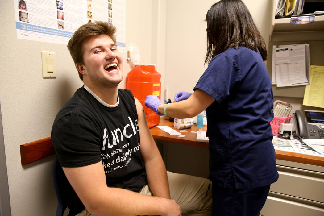 La enfermera principal de Salud Comunitaria Jocelyn Castillo le da a Cole Nisson, de 18 años, de Henderson una vacuna contra la gripe en la oficina del Distrito de Salud del Sur de Nevada en la o ...