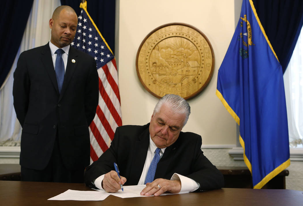 Con el recién juramentado fiscal general Aaron Ford a su lado, el gobernador de Nevada, Steve Sisolak, firma su primera orden ejecutiva que solicita un grupo de trabajo para abordar el acoso sexu ...