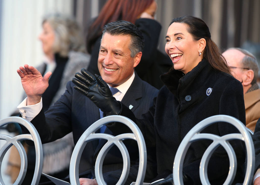 El ex gobernador Brian Sandoval y su esposa Lauralyn saludan a los miembros de la multitud antes de la inauguración en el Capitolio, en Carson City, Nevada, el lunes 7 de enero de 2019. (Cathleen ...