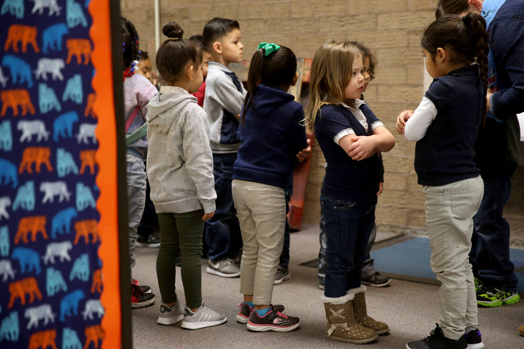 Los estudiantes de preescolar, Mia Caamano Palafox, derecha, e Iris Vázquez, se preparan para caminar a clase con su maestra Leigh Todd en Tate Elementary en Las Vegas el jueves 17 de enero de 20 ...