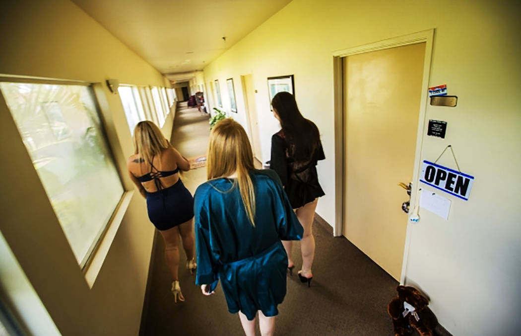 ARCHIVO.- Las trabajadoras sexuales Perla, a la izquierda, Erin y Emma, sus nombres escénicos, caminan por el pasillo en Sheri's Ranch, un centro de entretenimiento para adultos en Pahrump, Nevad ...