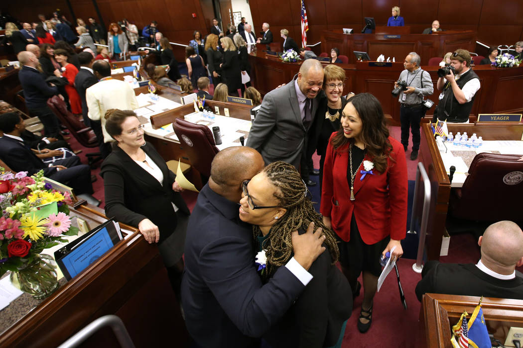 El presidente de la Asamblea Jason Frierson, D-Las Vegas, abraza a la asambleísta Dina Neal, D-North Las Vegas, mientras las legisladoras caminan por la cámara en el edificio legislativo en Cars ...