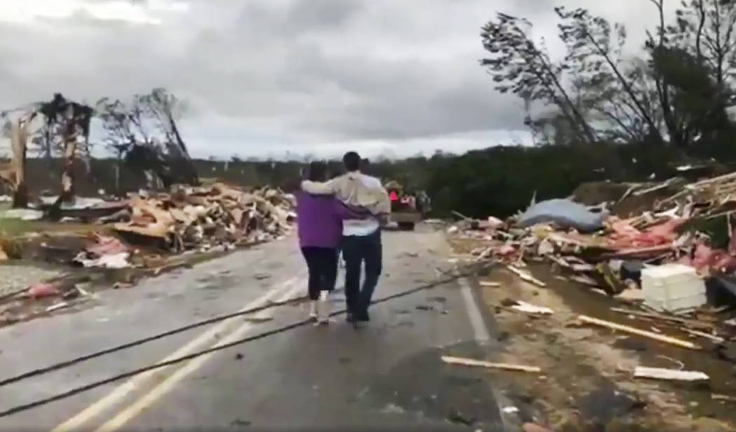 La gente camina entre escombros en el Condado de Lee, Alabama, después de lo que parecía ser un tornado que golpeó el área el domingo 3 de marzo de 2019. Las tormentas severas destruyeron casa ...