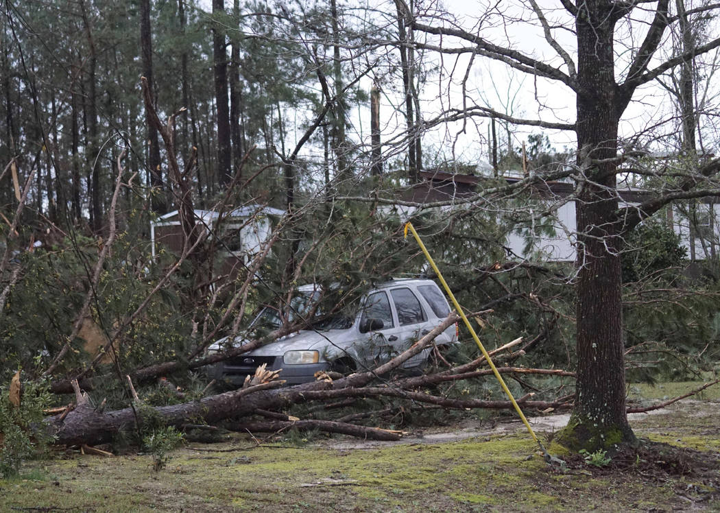 Un vehículo es atrapado debajo de árboles derribados a lo largo de Lee Road 11 en Beauregard, Alabama, el domingo 3 de marzo de 2019, luego de que un poderoso sistema de tormentas atravesara el ...