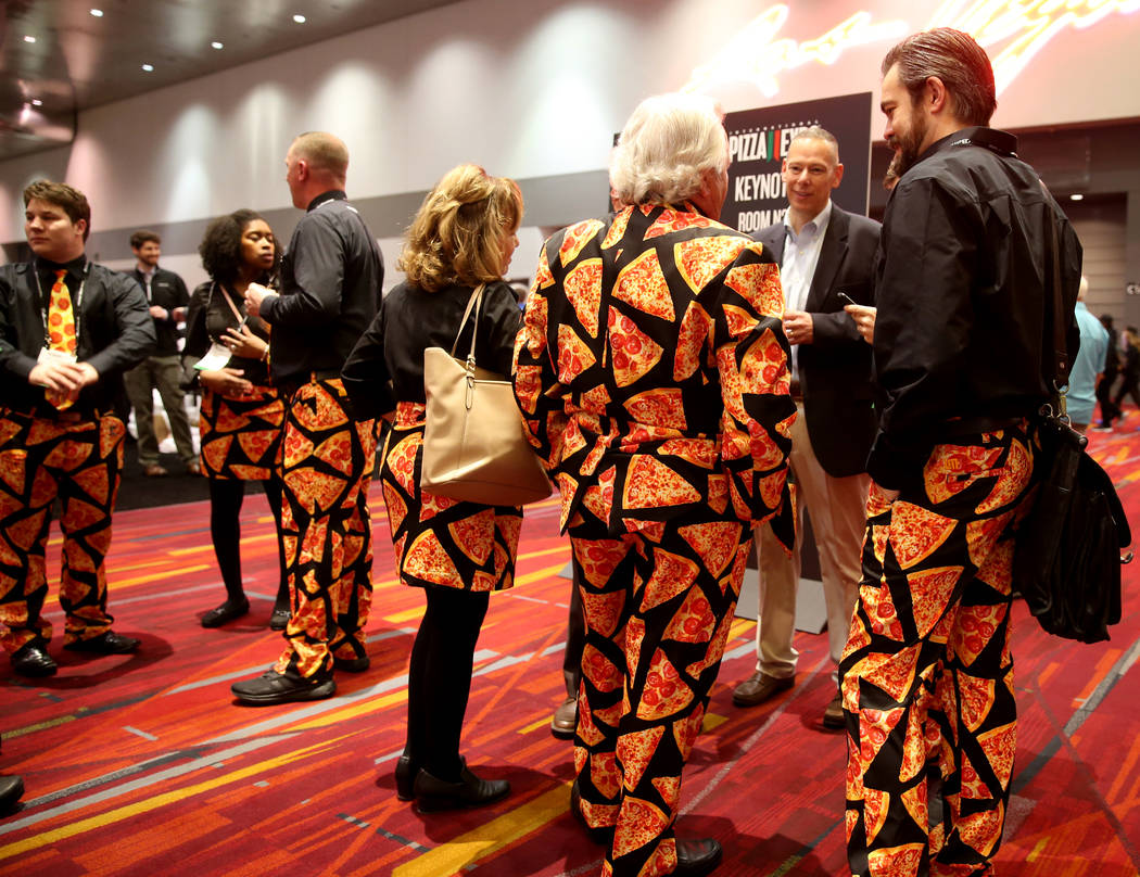 Pat Spaulding de Spaulding & Associates, Inc., de Brighton Michigan, en traje, habla con su equipo de Cheese Guys en la Exposición Internacional de Pizza en el Centro de Convenciones de Las Vegas ...
