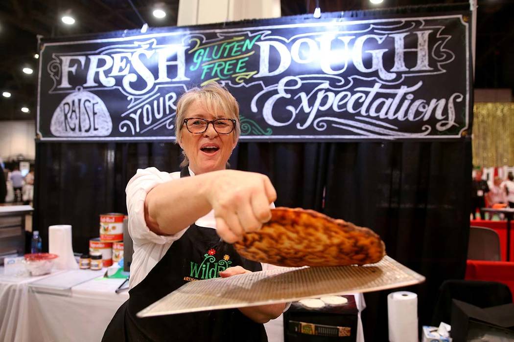 Kim Desch, de Wild Flour Bakery en Longmont, Colorado, muestra la parte inferior de su pizza sin gluten en la Exposición Internacional de Pizza en el Centro de Convenciones de Las Vegas el martes ...