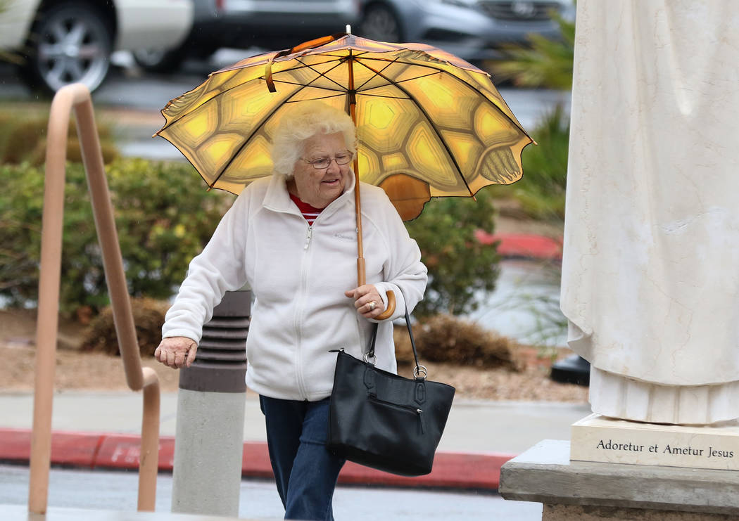 Una mujer sostiene un paraguas para protegerse de la lluvia mientras se dirige a la iglesia católica St. Viator el miércoles, marzo. 6, 2019, en Las Vegas. (Bizuayehu Tesfaye / Las Vegas Review- ...