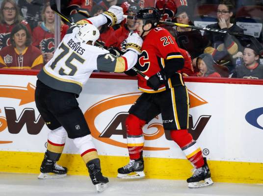 Ryan Reaves, de los Vegas Golden Knights, a la izquierda, controla a Garnet Hathaway de los Calgary Flames durante el tercer período de un juego de hockey de la NHL en Calgary, Alberta, el doming ...