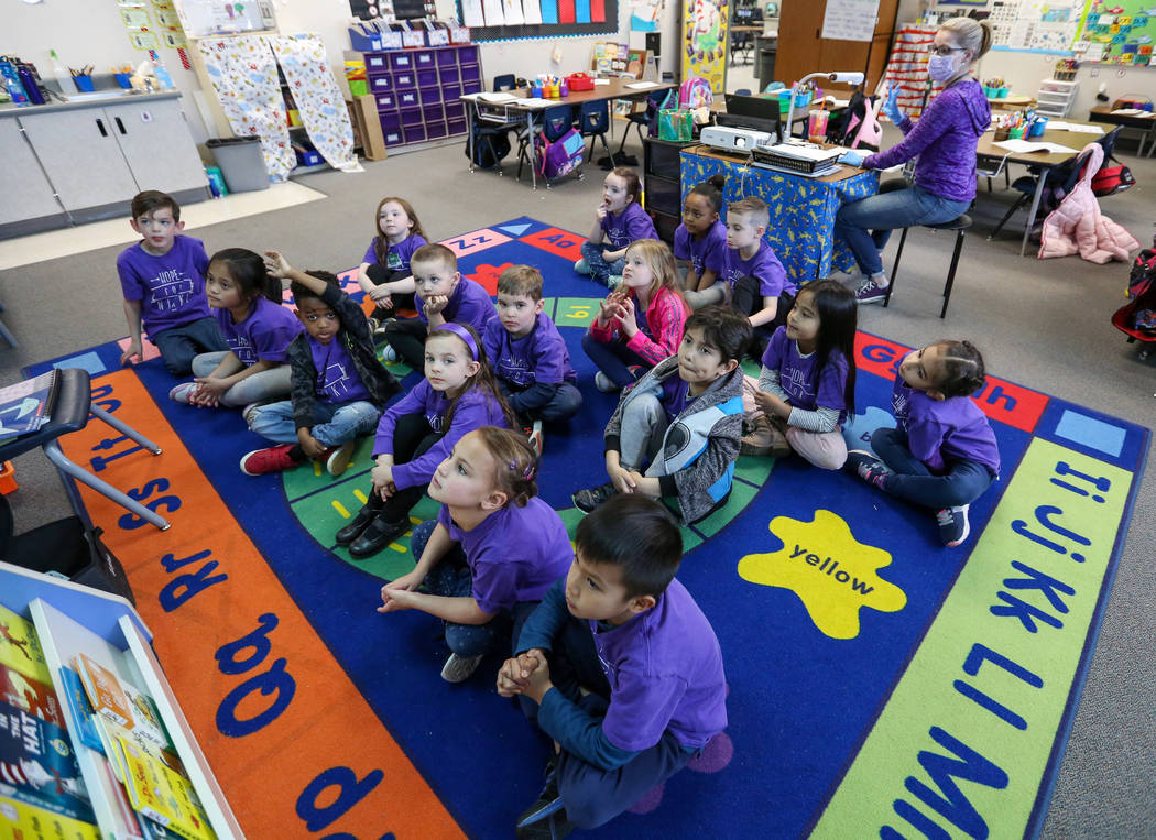 Estudiantes de kindergarten observan imágenes en la pantalla mientras su maestra Nikki McGuire, les hace preguntas durante una clase en Staton Elementary en Las Vegas, el martes 5 de marzo de 201 ...