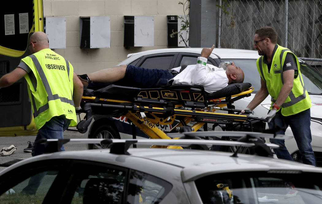 La policía y el personal de ambulancias ayudan a un hombre herido desde afuera de una mezquita en el centro de Christchurch, Nueva Zelanda, el viernes 15 de marzo de 2019. (AP Photo / Mark Baker)