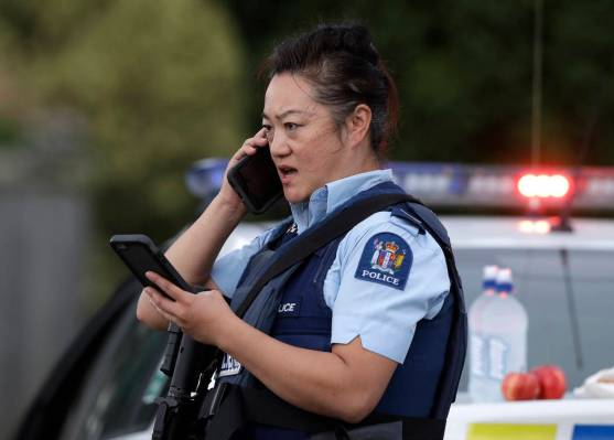 Un oficial de policía habla en su teléfono como una barricada cerca de un tiroteo masivo en una mezquita en Linwood, Christchurch, Nueva Zelanda, el viernes 15 de marzo de 2019. Múltiples perso ...