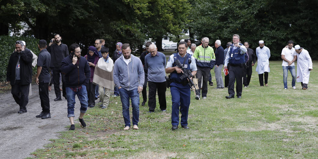 La policía escolta a testigos que se alejan de una mezquita en el centro de Christchurch, Nueva Zelanda, el viernes 15 de marzo de 2019. (AP Photo / Mark Baker)