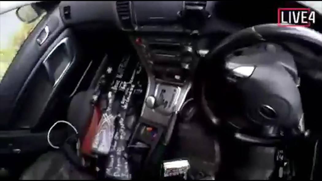 Esta imagen tomada del video del presunto tirador, que se filmó el viernes 15 de marzo de 2019, lo muestra mientras conduce y mira tres armas en el lado del pasajero de su vehículo en Nueva Zela ...