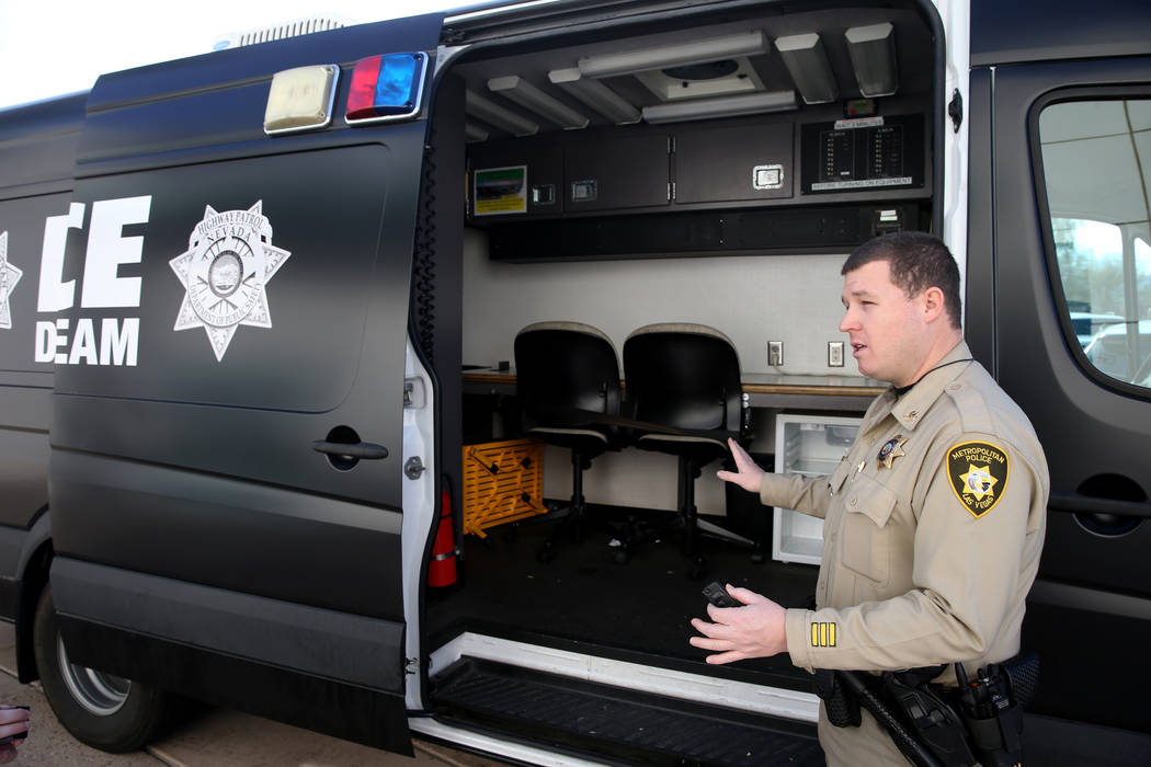 El oficial de tránsito del Departamento de Policía Metropolitana, Mike Thiele, muestra la camioneta utilizada para el procesamiento y el transporte de los supuestos conductores incapacitados por ...