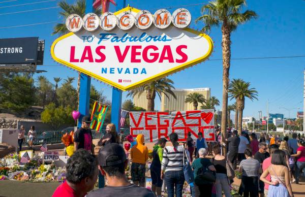 El sábado 7 de octubre de 2017, la gente visita un monumento improvisado para víctimas del tiroteo masivo del 1 de octubre cerca del cartel de "Bienvenido a Las Vegas". Chase Stevens Las Vegas R ...
