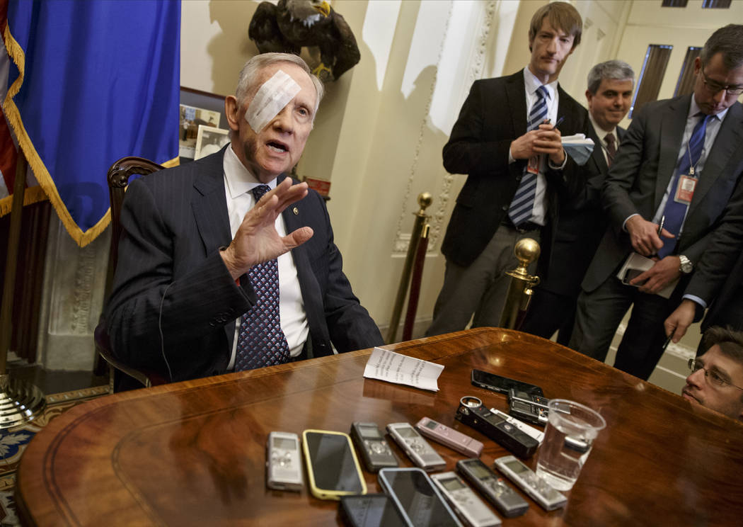 El entonces líder de la minoría en el Senado, Harry Reid, de Nevada, conversa con reporteros en Capitol Hill en Washington, DC, el 22 de enero de 2015, por primera vez después de sufrir una les ...