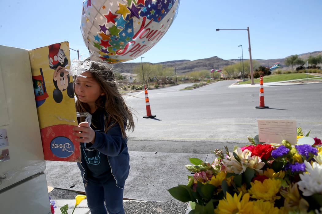 Evelyn Yoshimori, de 7 años, firma un memorial en South Fort Apache Road en Faiss Park en Las ...