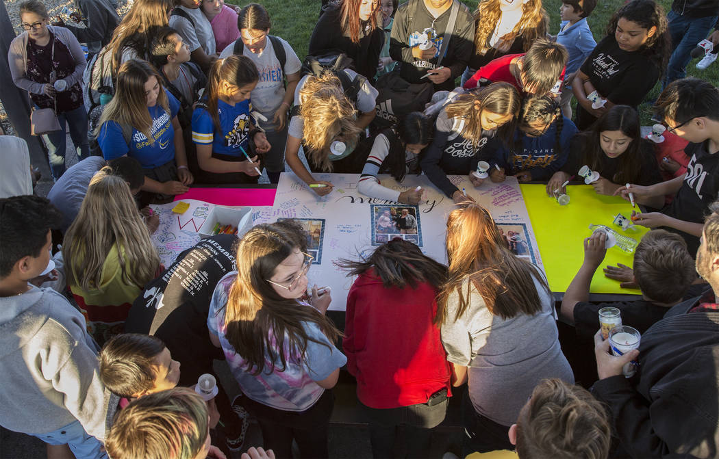 Un gran grupo de niños firman un cartel que honra la memoria de Jonathan Smith, de 12 años, d ...