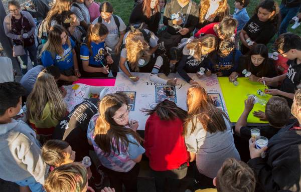 Un gran grupo de niños firman un cartel que honra la memoria de Jonathan Smith, de 12 años, d ...