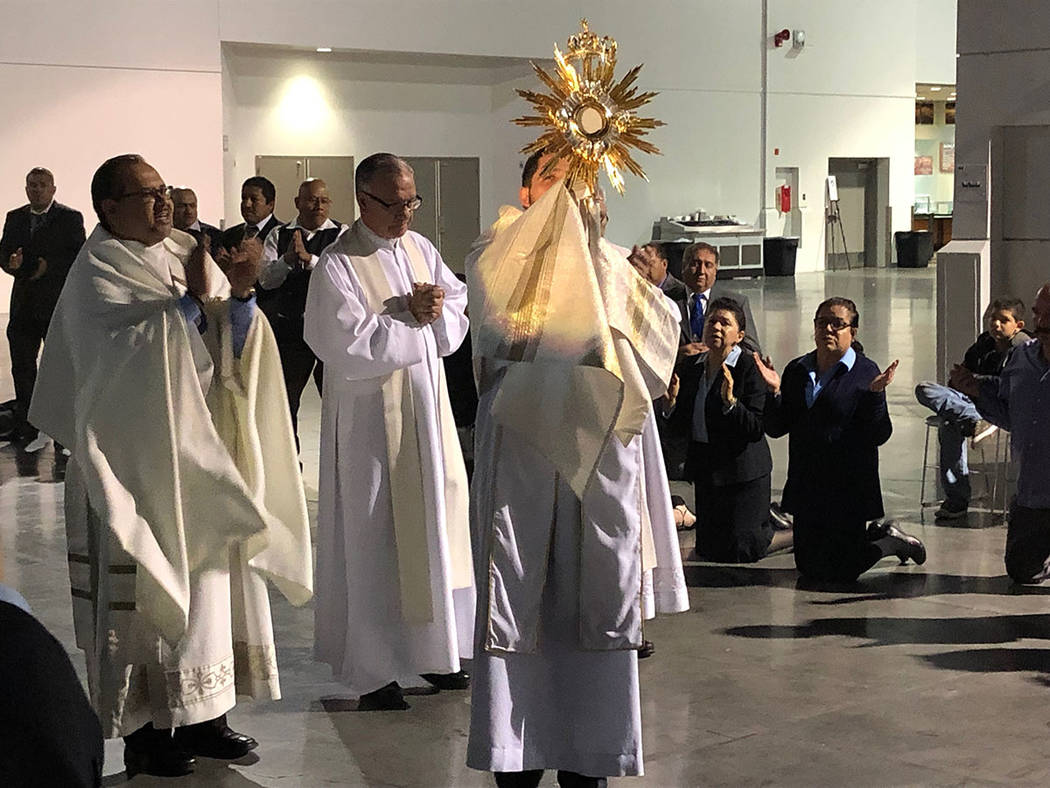 El reverendo Juan P. Mantilla levanta el Santísimo. Al centro el padre Gregorio León, al inic ...