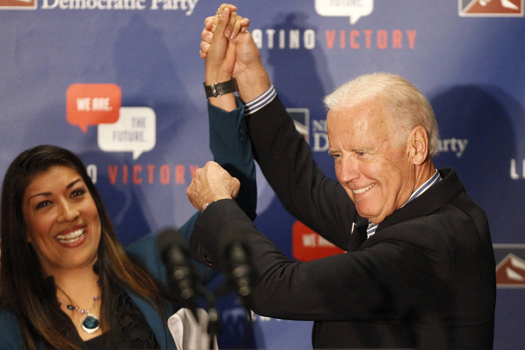 Lucy Flores, a la izquierda, y Joe Biden, apoyan a simpatizantes durante un evento de votación ...