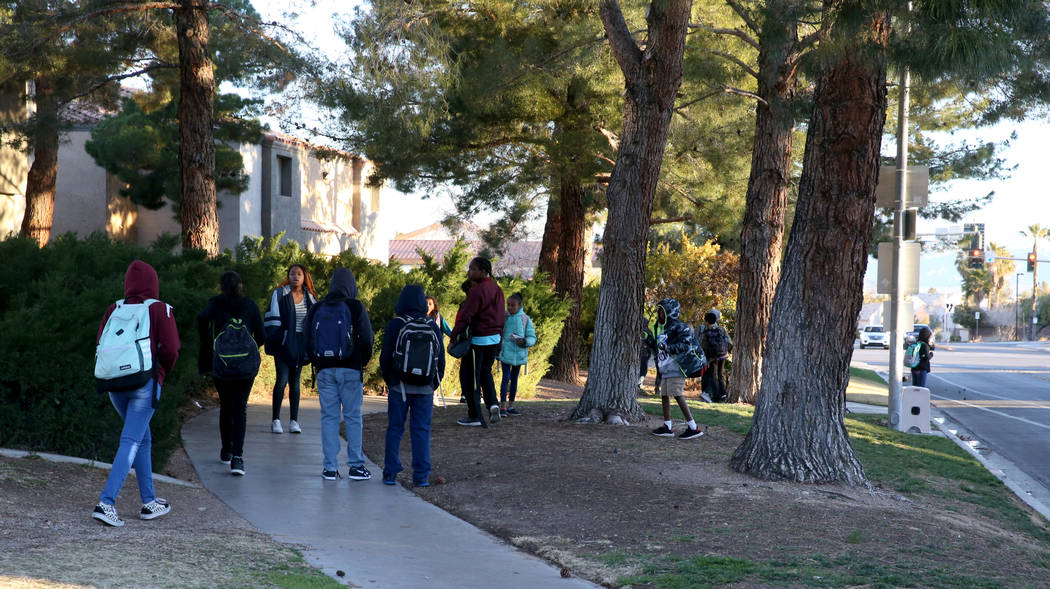 Los estudiantes esperan por el autobús escolar en Soaring Gulls Drive cerca de Cheyenne Avenue ...