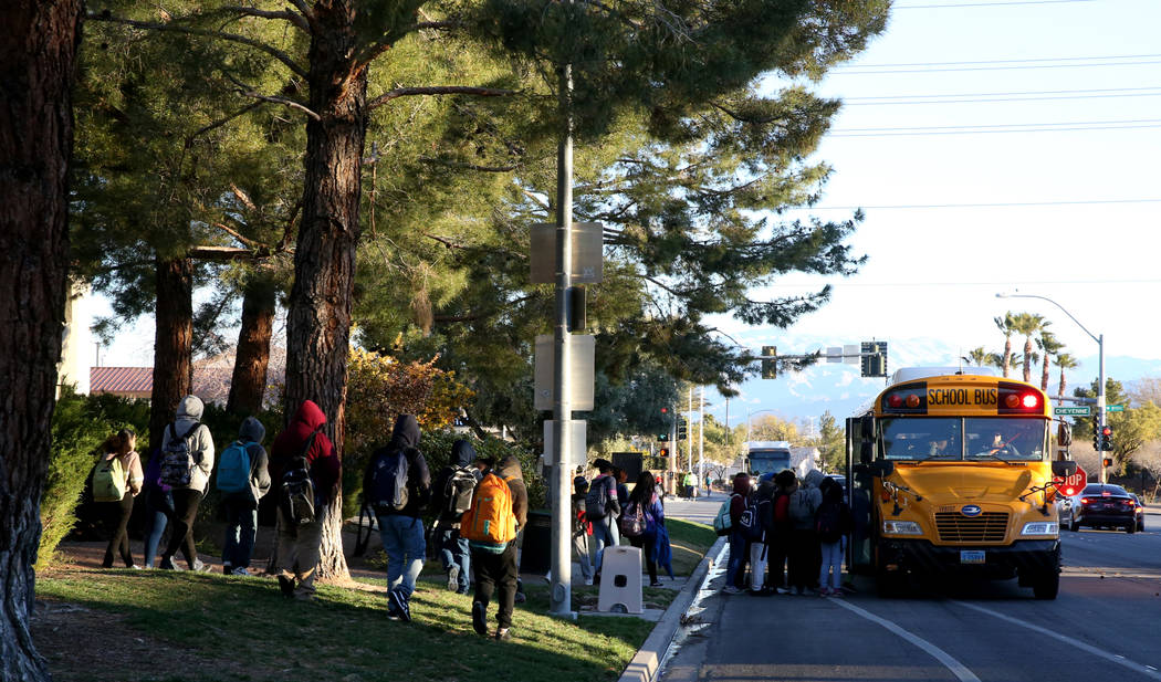 Los estudiantes suben al autobús escolar en Soaring Gulls Drive cerca de Cheyenne Avenue en De ...