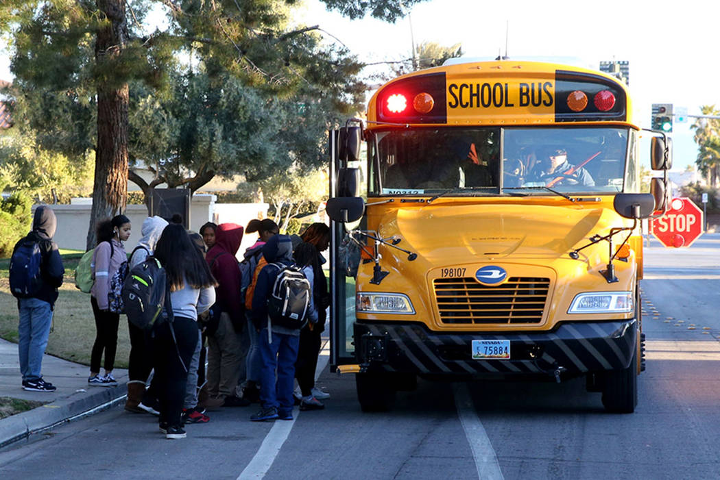 Los estudiantes suben al autobús escolar en Soaring Gulls Drive cerca de Cheyenne Avenue en De ...