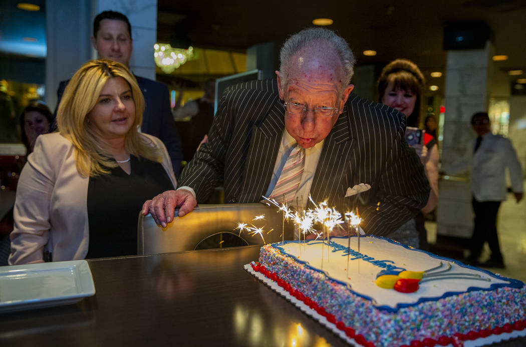 El ex alcalde de Las Vegas, Óscar Goodman, intenta apagar velas sobre un pastel de felicitacio ...