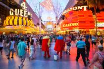 Modelos esperan para posar con los turistas para obtener propinas a lo largo de Fremont Street ...