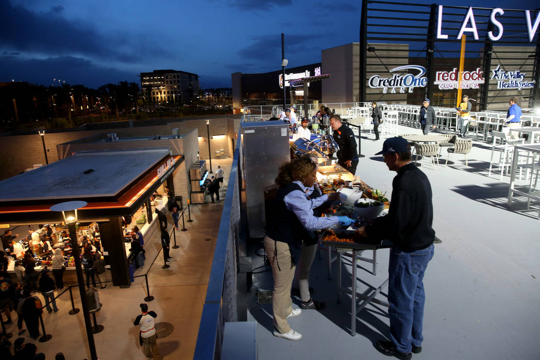 Fans toman comida en la primer noche de apertura de los Aviators de Las Vegas en el estadio de ...