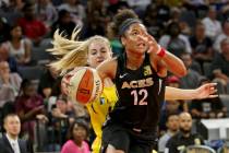 La alera de Las Vegas Aces, Nia Coffey (12), empuja el balón a través de la defensa de Los An ...