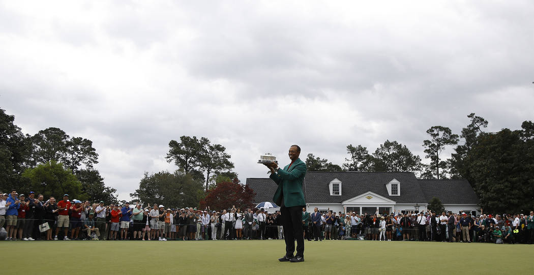 Tiger Woods sostiene su trofeo después de ganar el torneo de golf Masters el domingo 14 de abr ...