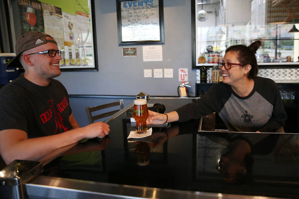 Chelsie Kesjaral, a la derecha, sirve una cerveza para Max Lovelady, en CraftHaus Brewery en He ...
