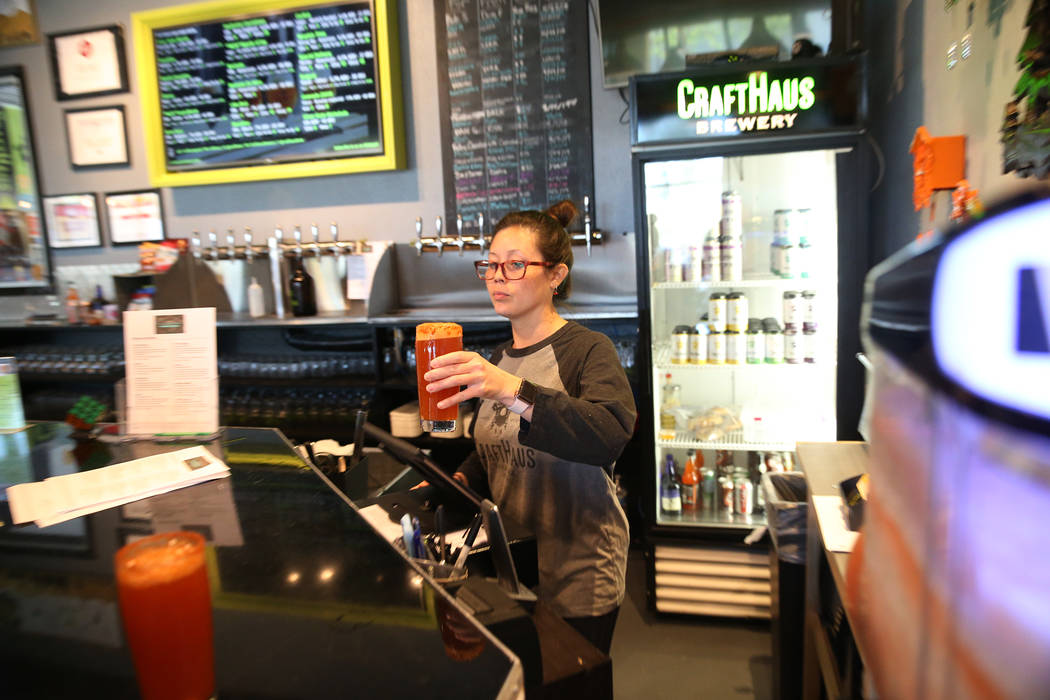 Chelsie Kesjaral, a la derecha, sirve una cerveza para Max Lovelady, en CraftHaus Brewery en He ...