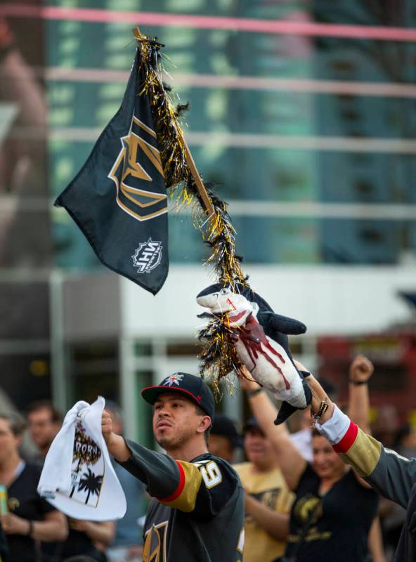 Un fan de los Golden Knights enarbola una bandera con un sangriento tiburón mientras celebra u ...