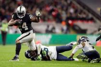 Marshawn Lynch (24), corredor de los Oakland Raiders, es abordado por el esquinero Shaquill Gri ...