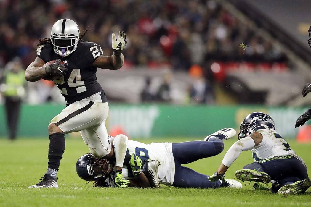 Marshawn Lynch (24), corredor de los Oakland Raiders, es abordado por el esquinero Shaquill Gri ...