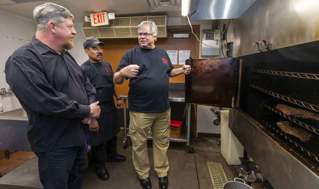 El nuevo empleado Ron Cochran, recibe entrenamiento del gerente de cocina Álvaro Hernández y ...