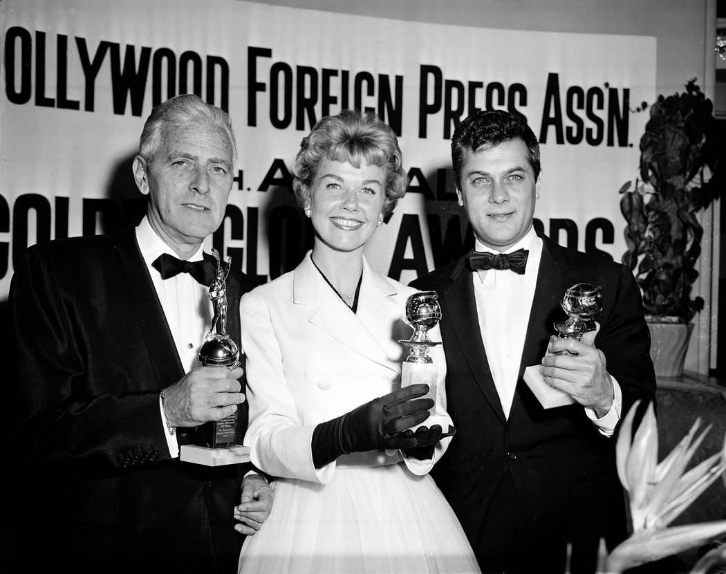 La actriz Doris Day, con Tony Curtis, a la derecha, y Buddy Adler posan con sus premios present ...