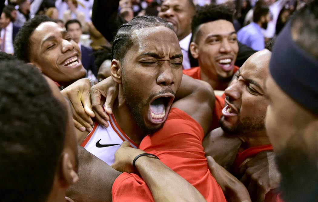 El delantero de los Toronto Raptors, Kawhi Leonard, en el centro, celebra su canasta ganadora d ...