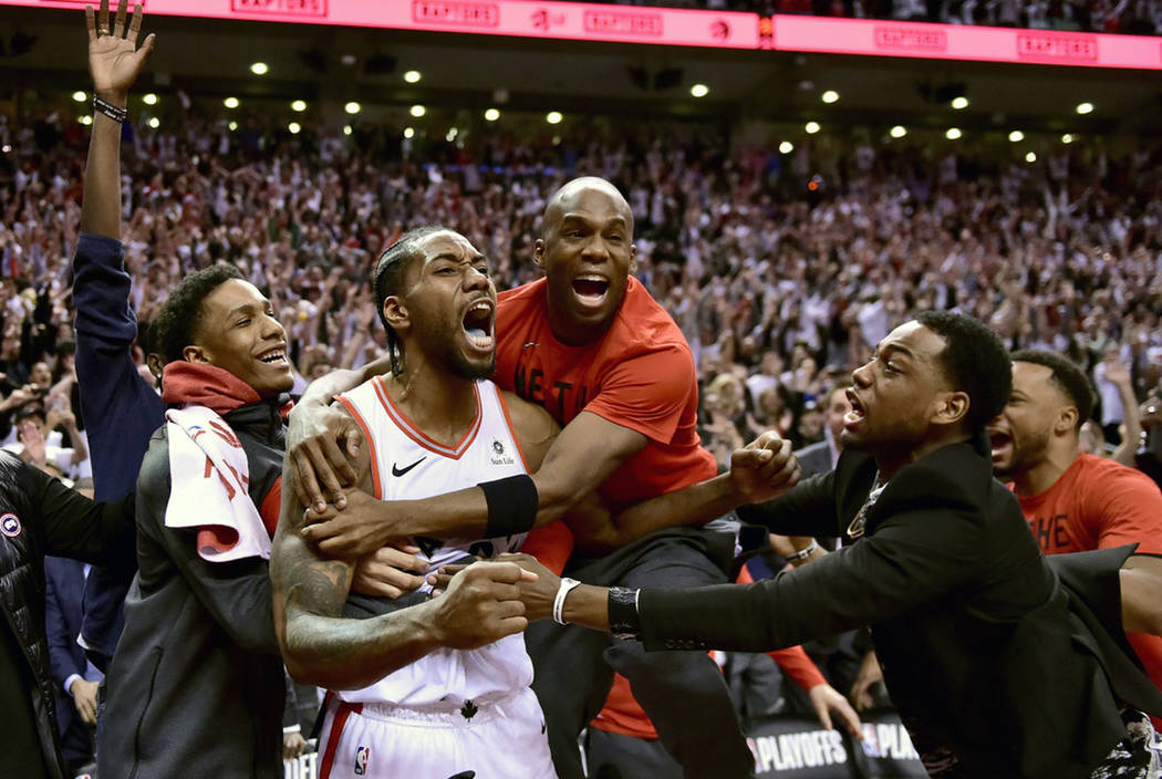 El delantero de los Toronto Raptors, Kawhi Leonard, en el centro, celebra su canasta ganadora d ...