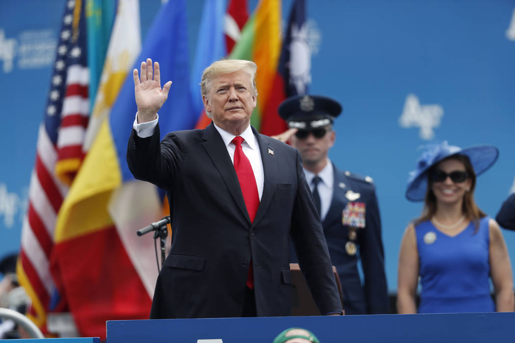 El presidente Donald Trump saluda mientras sube al escenario para hablar en la graduación de l ...