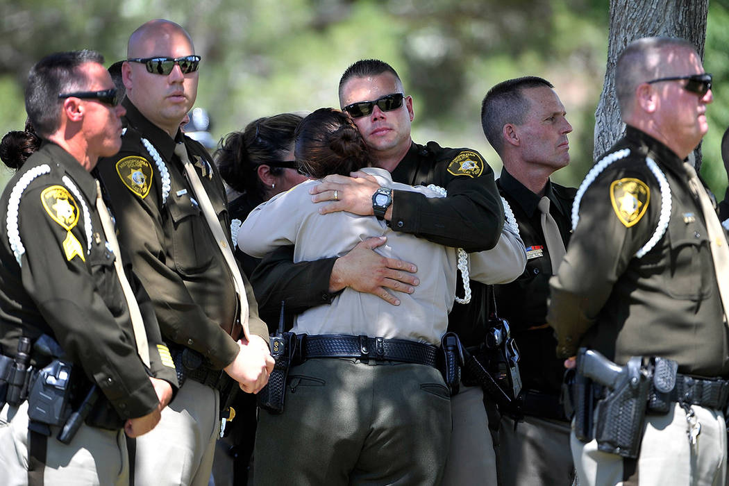 El 12 de junio de 2014, en Las Vegas, los policías de Las Vegas consuelan a cada uno durante u ...