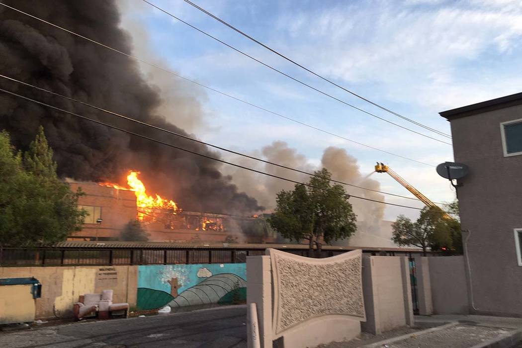 Humo denso y llamas se originan de un incendio en un complejo comercial cerca de Paradise Road ...