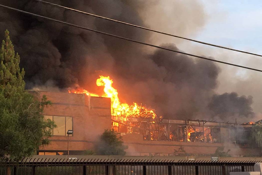 Humo denso y llamas se originan de un incendio en un complejo comercial cerca de Paradise Road ...