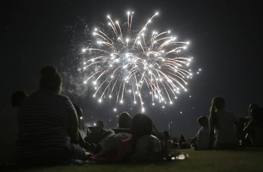 La gente disfruta del espectáculo de fuegos artificiales en la celebración del cuatro de juli ...